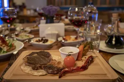 a table with a plate of food and glasses of wine at ERTA SOYAK THERMAL OTEL in Çekirge