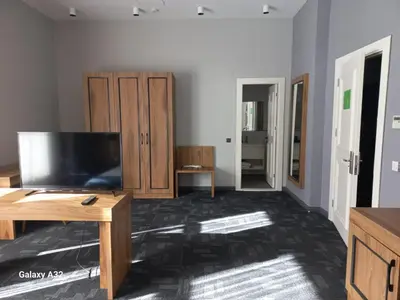 a living room with a flat screen tv and wooden furniture at ERTA SOYAK THERMAL OTEL in Çekirge