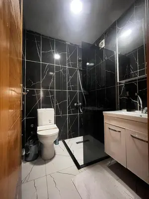 a black tiled bathroom with a toilet and a sink at 216 Hill Suites in Istanbul