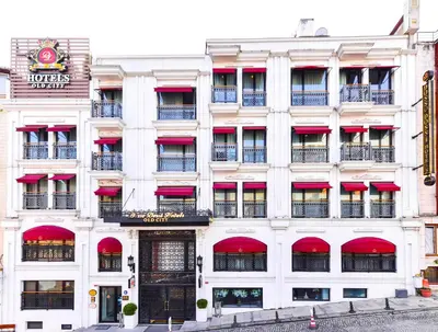 a large white building with red awnings at Dosso Dossi Hotels Old City in Istanbul