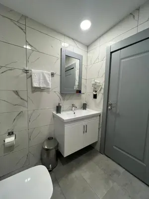 a bathroom with a sink and a mirror and a toilet at Lynda Hotel in Istanbul