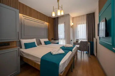 a hotel room with two beds and a television at Lynda Hotel in Istanbul