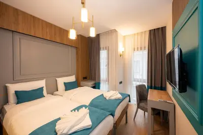 a hotel room with two beds and a flat screen tv at Lynda Hotel in Istanbul