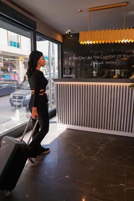 a woman walking through a store with her luggage at Homey AirPort Hotel in Arnavutköy