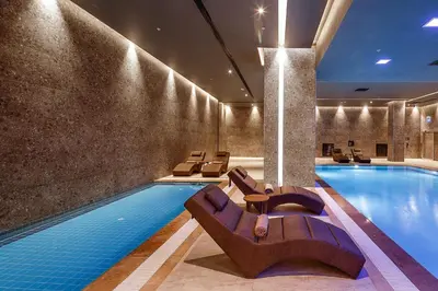 a pool in a hotel with lounge chairs and a swimming pool at Dedeman Kartepe Kocaeli in Kocaeli