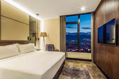 a hotel room with a bed and a large window at Dedeman Kartepe Kocaeli in Kocaeli