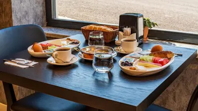 a table with plates of food and drinks on it at Görükle Alpaş Yaşam Hotel in Bursa