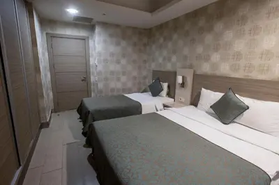 a hotel room with two beds and a door at Sen Otel in Sakarya