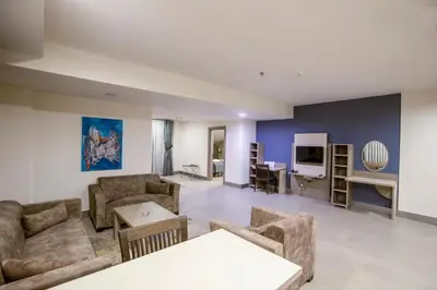 a living room with couches and a table and a tv at Sen Otel in Sakarya