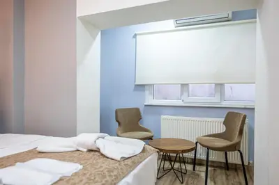 a bedroom with two chairs and a table and a bed at LAOS OTEL in Istanbul
