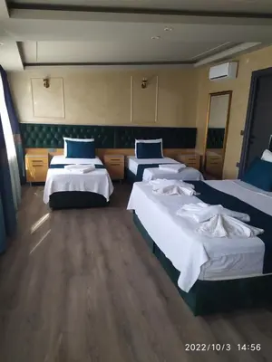 a hotel room with three beds with blue pillows at THE MOSS Hotel in Istanbul