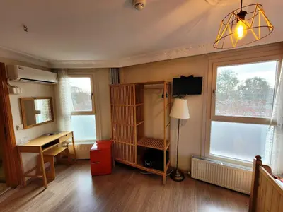 a room with a desk and a table and two windows at Masif House in Istanbul