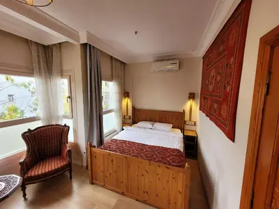 a bedroom with a bed and a chair and a window at Masif House in Istanbul