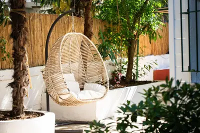 a wicker chair hanging from a tree in a yard at No16 Ada in Adalar