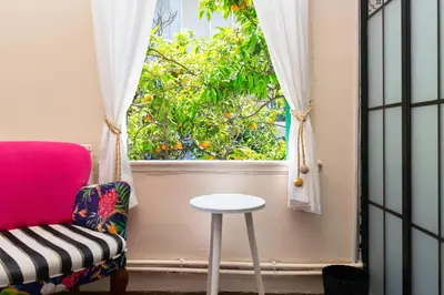 a pink chair and a stool in front of a window at No16 Ada in Adalar