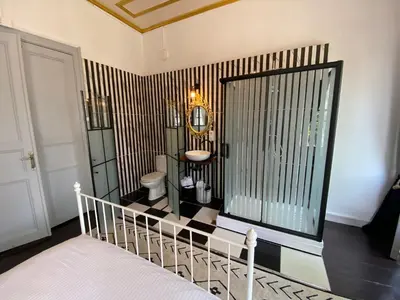 a bedroom with a bathroom with a sink and a mirror at No16 Ada in Adalar