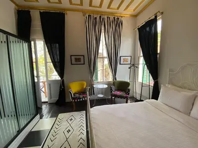 a bedroom with a bed and two chairs and windows at No16 Ada in Adalar