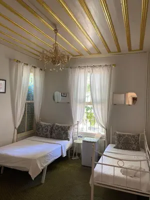 a bedroom with two beds and a ceiling with a chandelier at No16 Ada in Adalar