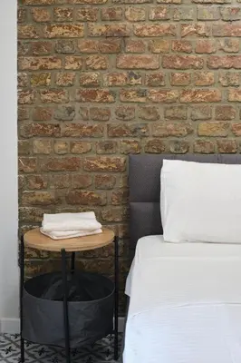 a bed and a table next to a brick wall at Sunflower Apartments in Istanbul