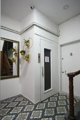 a white room with a door and a mirror and a hallway at Sunflower Apartments in Istanbul