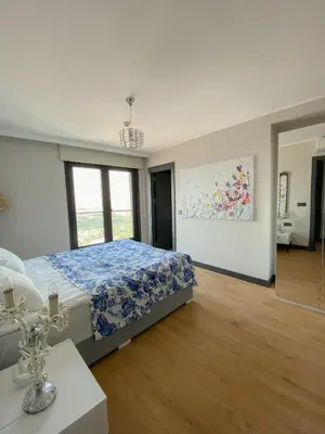 a bedroom with a bed with a blue comforter at Luxury Duplex with Terrace Apartment by Siena Suites in Istanbul