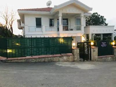 a house with a green gate in front of it at Sapanca Manzara Villa 2 Isıtma Havuzlu in Sapanca