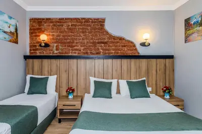 two beds in a room with a brick wall at La Pera Suites Hotel in Istanbul