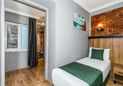 a bedroom with a bed and a brick wall at La Pera Suites Hotel in Istanbul