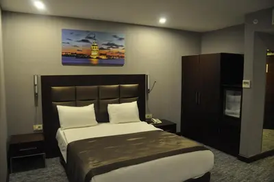 a bedroom with a large bed and a tv at Happy Inn Gebze Hotel in Kocaeli