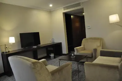 a living room with chairs and a flat screen tv at Happy Inn Gebze Hotel in Kocaeli