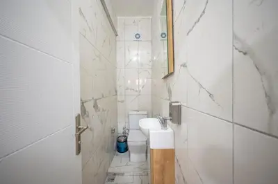 a white bathroom with a sink and a toilet at XALİLA HOSTEL & CAFE LADİES ROOM in Istanbul