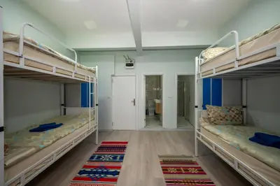 a room with three bunk beds and a hallway at XALİLA HOSTEL & CAFE LADİES ROOM in Istanbul