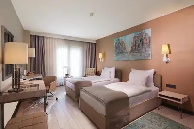 a hotel room with two beds and a desk at The Gate Ataşehir Finance Centre in Istanbul
