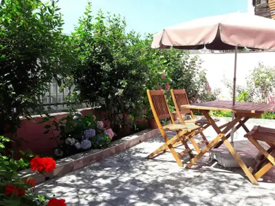 a picnic table and chairs with an umbrella and flowers at Golden Life GL in Istanbul