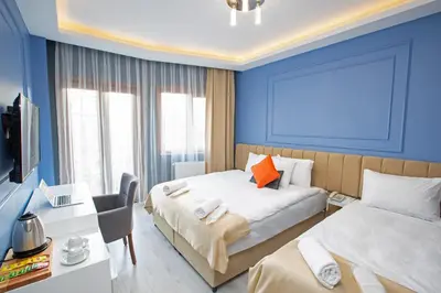 a bedroom with two beds and a desk and a tv at Taksim Square Leon's Hotel in Istanbul