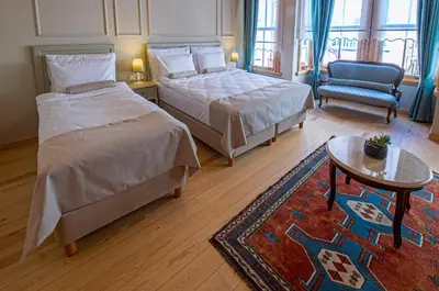 a bedroom with two beds and a table and a chair at İkiz Konak Boutique Hotel in Istanbul