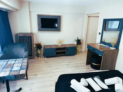 a living room with a tv and a couch and a table at Nişantaşı Diamond Hotel in Istanbul