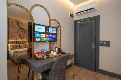 a room with a desk and a bed and a mirror at World Class Hotel - Istanbul Airport in Arnavutköy