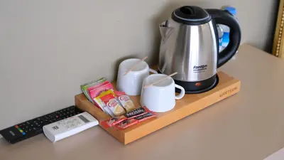 a coffee maker and mugs on a table next to a keyboard at By Kinyas Hotel in Istanbul