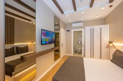 a living room with a couch and a tv on a wall at Hotel Grand İstanbul in Istanbul