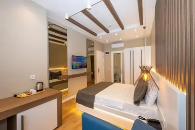 a bedroom with a bed and a desk and a tv at Hotel Grand İstanbul in Istanbul