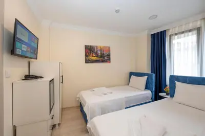 a hotel room with two beds and a tv at Hotel Grand İstanbul in Istanbul