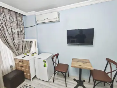 a kitchen with a refrigerator and a table and chairs at Taksim Rozenda Residence Hotel in Istanbul