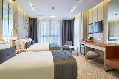 a hotel room with two beds and a desk at THE HUBİ HOTEL in Istanbul