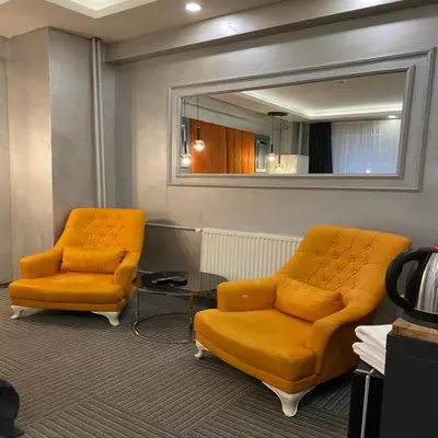 two orange chairs and a mirror in a waiting room at Valeron Suit Premium in Istanbul