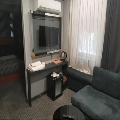 a living room with a couch and a television at Valeron Suit Premium in Istanbul