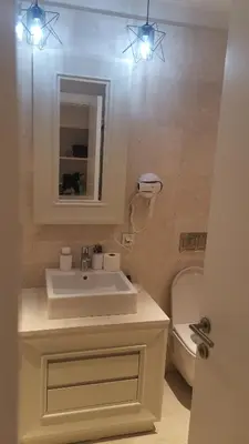 a bathroom with a sink and a toilet and lights at My G yoo Apartment #2 in Istanbul