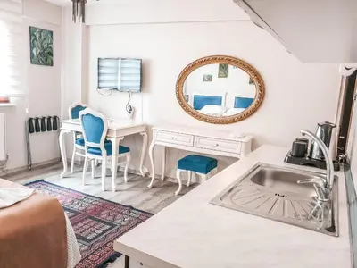 a white kitchen with a sink and a mirror at 1453Apartments in Istanbul