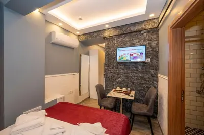 a room with a bed and a table and a tv at Taksim Story Residence in Istanbul