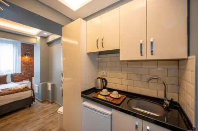 a kitchen with white cabinets and a sink in a room at Taksim Story Residence in Istanbul